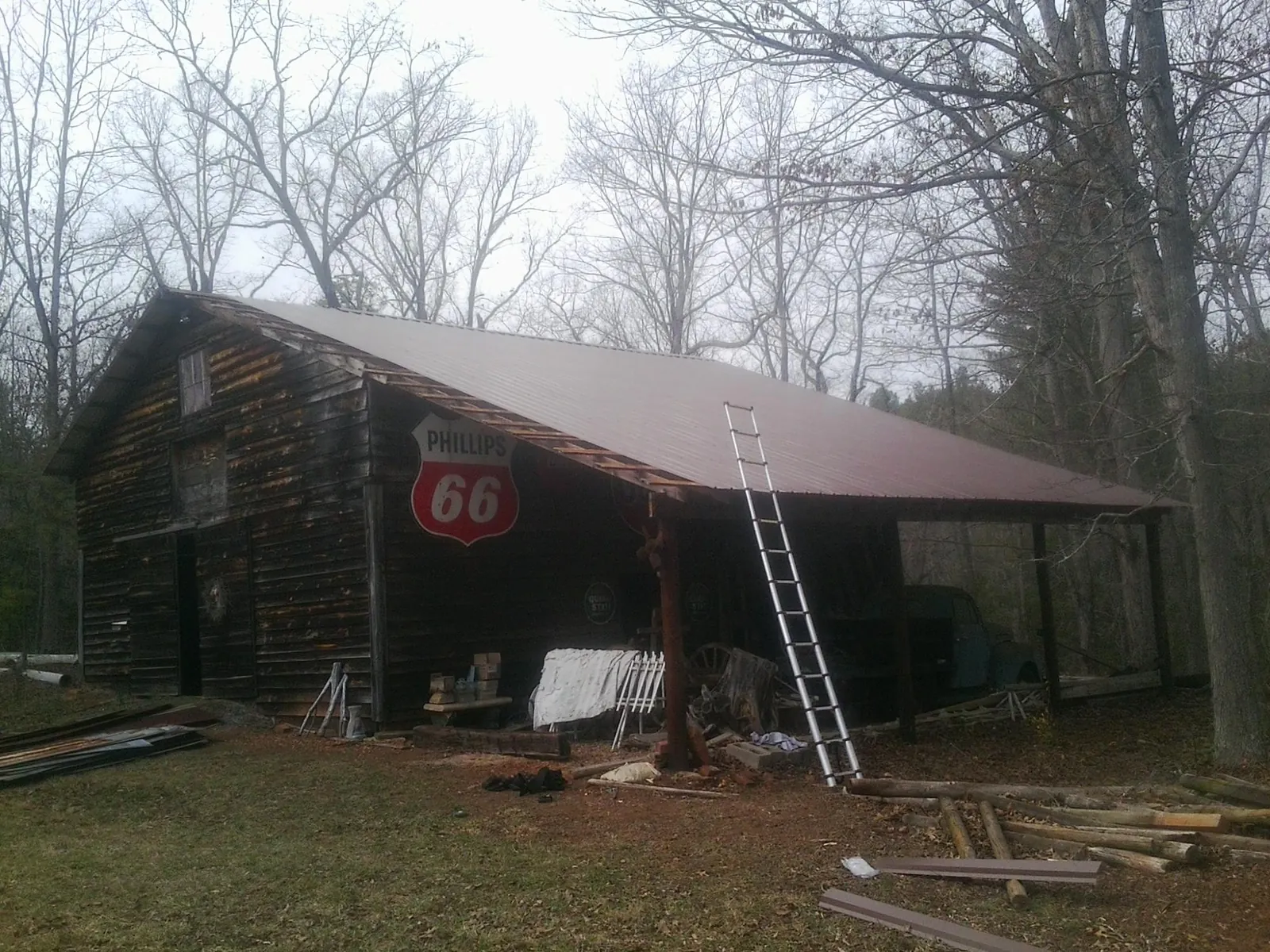 New metal roof on an open sided timber barn with a vintage sign in Muncie