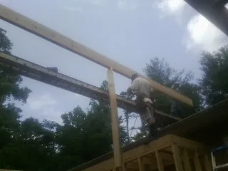 Carpenter setting a ridge beam over a new addition frame — Ice Dam Removal by Roofing Brothers in Muncie