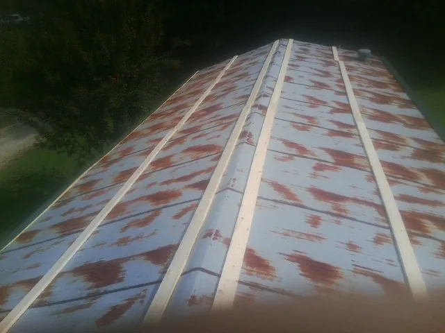 Rusted metal roof panels with new wood purlins before replacement — Storm Damage Roof Repair in Muncie by Roofing Brothers
